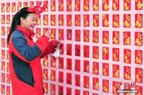 資料圖：2018年2月16日,，大年初一，游客來(lái)到天津方特歡樂(lè)世界紅包墻前搶包紅,。<a target='_blank' href='http://www.chinanews.com/'>中新社</a>記者 佟郁 攝