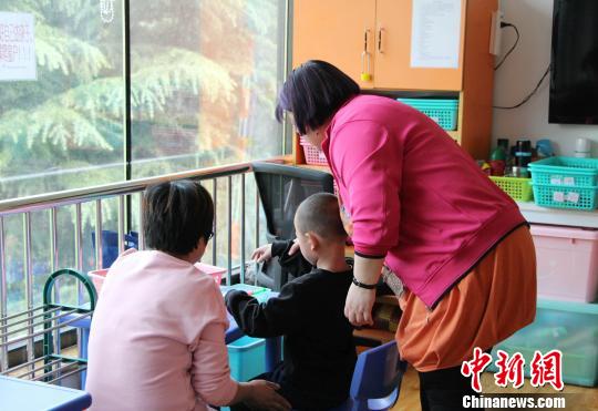 走進濟南安安特殊兒童康復(fù)中心，老師和家長正帶著自閉癥孩子玩游戲,?！≮w曉 攝