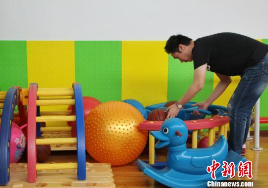 圖為自閉癥康復(fù)教師正在收拾整理自閉癥孩子日常鍛煉所使用的器具,。　趙曉 攝