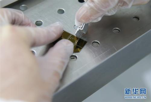 4月11日,，復(fù)旦大學(xué)微電子學(xué)院教授張衛(wèi),、周鵬團(tuán)隊成員劉春森在實驗室內(nèi)對硅片進(jìn)行切割。 新華社記者 丁汀 攝 圖片來源：新華網(wǎng)