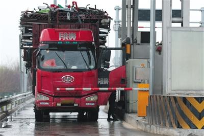 4月13日,，京津高速臺湖收費站，一名大貨車司機從車上下來取高速卡,。本版攝影/新京報記者 朱駿