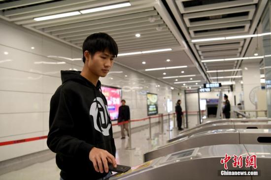 12月28日,，一名乘客使用藍牙感應通過地鐵閘機,。當日,，南寧地鐵2號線開通試運營，同時全線開啟手機感應過閘服務,，市民下載APP后,，打開藍牙，即可感應通關,。 <a target='_blank' href='http://www.chinanews.com/'>中新社</a>記者 俞靖 攝