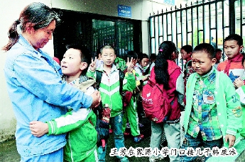 王芳在聚源小學(xué)門口接兒子韓康泳,。本報記者  田福良  攝