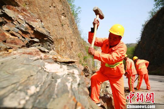 楊衛(wèi)東帶領(lǐng)工友們正在清理落石,。　劉繼東 攝