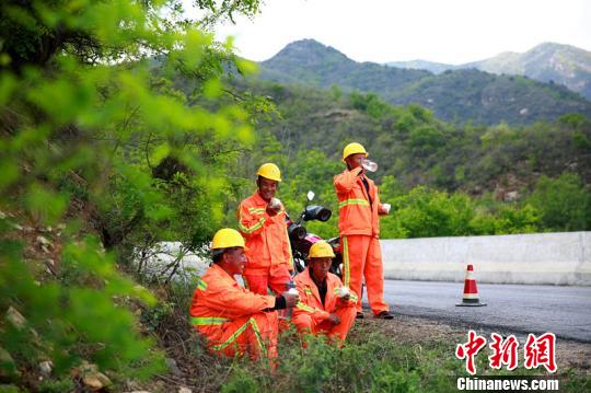 臨近中午,，楊衛(wèi)東和工友們在路旁休息時，拿出自帶的干糧和水補(bǔ)充體力,?！⒗^東 攝