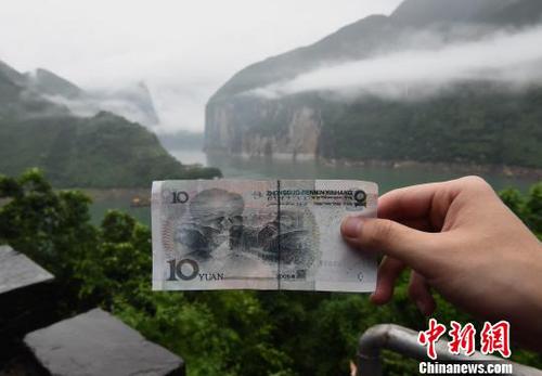 圖為游客在人民幣十元背景圖實景地駐足參觀,，并拍照留念?！≈芤恪z