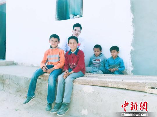 資料圖：鄧杰在突尼斯的鄉(xiāng)村義診，跟當(dāng)?shù)貎和嫌傲裟?。　受訪者供圖 攝