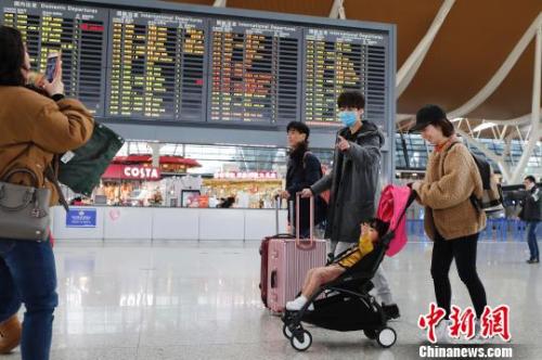 旅客帶著孩子前往辦票柜臺(tái)辦理登機(jī)手續(xù),。　殷立勤 攝
