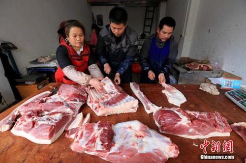 居民在家中切豬肉,。譚凱興 攝