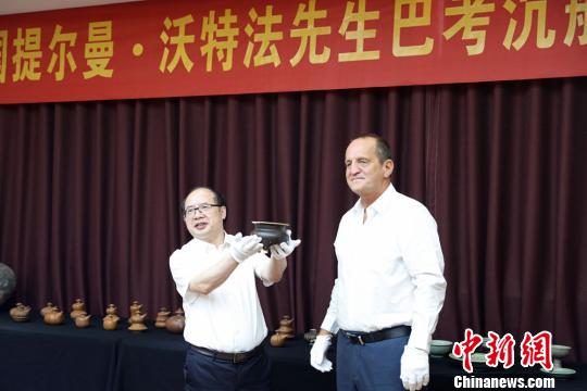  提爾曼-沃特法（右）向湖南省博物館捐贈巴考沉船代表文物明景德鎮(zhèn)窯醬釉三足香爐。湖南省博物館供圖