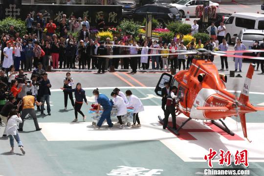 5月23日,，遼寧省人民醫(yī)院完成中國東北首例異地航空醫(yī)療轉(zhuǎn)運任務(wù),。圖為急救人員立即將患者抬上急救床?！≈烀饔?攝