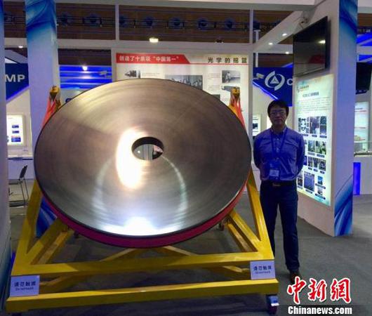 張舸博士和展出的碳化硅反射鏡,。中科院長春光機所供圖