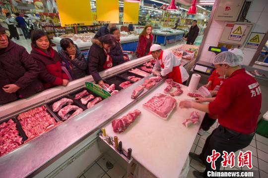 山西太原,，超市員工在為民眾分解豬肉。張?jiān)?攝