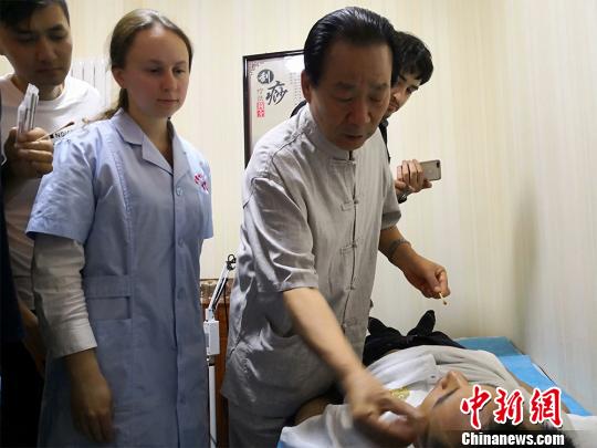 圖為甘肅岐黃國醫(yī)館負責(zé)人何天有現(xiàn)場向國外中醫(yī)愛好者教學(xué)“針灸”,。　魏建軍 攝