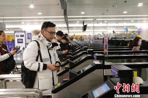 資料圖：旅客在浦東機(jī)場(chǎng)T2航站樓出境大廳內(nèi)掃登機(jī)牌,、刷護(hù)照、按指紋拍照片,，10多秒就能自助出境通關(guān),。　殷立勤　攝