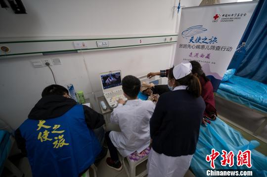 圖為醫(yī)療專家通過心臟彩超篩查先心病患兒,?！『闻罾?攝