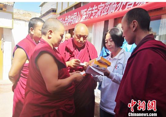 圖為專家為僧人叮囑服藥注意事項(xiàng),。　南如卓瑪 攝