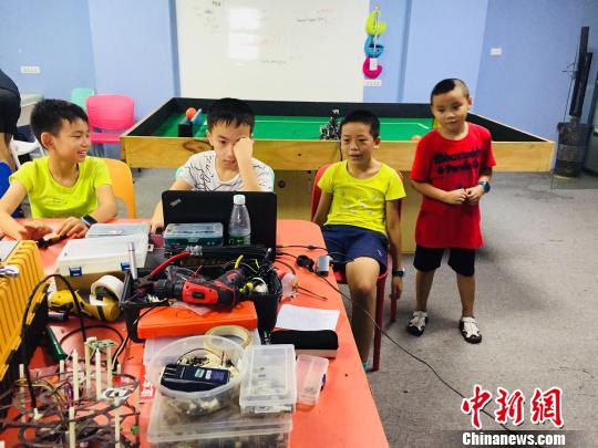 7月21日,，在廣西柳州一家培訓(xùn)機構(gòu)，學(xué)生動手制作機器人,?！≈転t男 攝