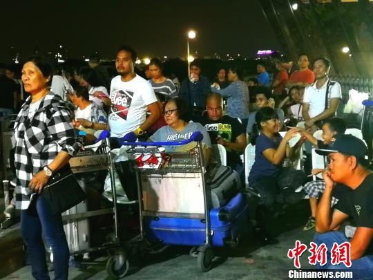 候機廳外不少滯留旅客將行李放在手推車上，靠著休息,?！￡P向東 攝