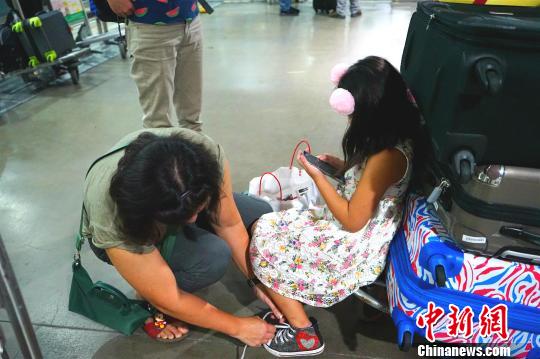 候機廳外不少滯留旅客將行李放在手推車上,，靠著休息,。　關向東 攝