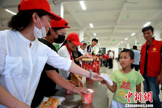 8月24日,，志愿者在濰坊壽光市營里鎮(zhèn)第二初級中學(xué)安置點為災(zāi)民發(fā)放救援物資?！×籂?攝