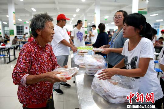 8月24日,，志愿者在濰坊壽光市營里鎮(zhèn)第二初級中學(xué)安置點為災(zāi)民發(fā)放救援物資,。　梁犇 攝