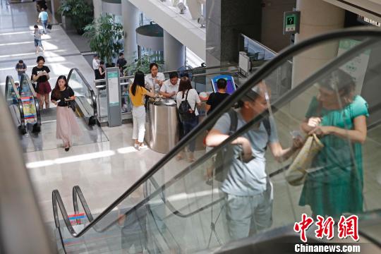 上海市公安局出入境管理局內(nèi),，民眾正在咨詢和辦理相關(guān)業(yè)務(wù)?！∫罅⑶?攝