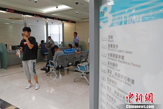 上海市公安局出入境管理局內(nèi),，民眾正在咨詢和辦理相關(guān)業(yè)務(wù),。　殷立勤 攝