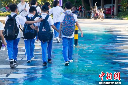 學(xué)生在海口首條3D斑馬線上通過,。　凌楠 攝