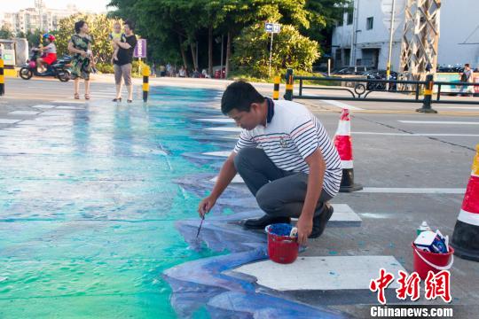 ?？谑讞l3D斑馬線施工員在做最后的收尾工作,。　凌楠 攝
