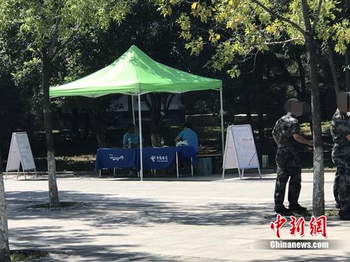中國電信在某高校內(nèi)擺攤出售手機卡，旁邊就是正在軍訓的學生,。<a target='_blank' href='http://www.chinanews.com/' >中新網(wǎng)</a> 吳濤 攝
