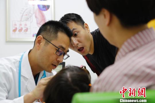 門診醫(yī)生正在耐心的給家長(zhǎng)講解孩子的病情?！∫罅⑶凇z