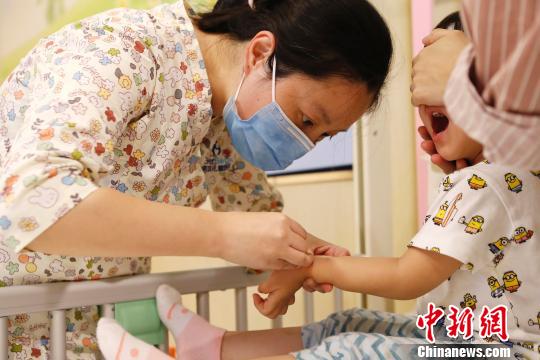 醫(yī)護(hù)人員正在為孩子進(jìn)行輸液前的準(zhǔn)備工作,?！∫罅⑶凇z