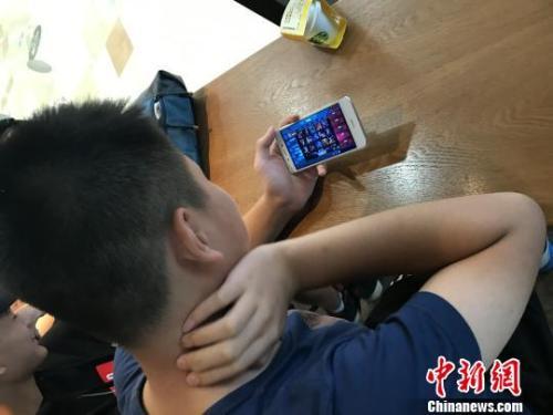資料圖：學(xué)生在玩熱門手機(jī)游戲,?！√K飛宇 攝