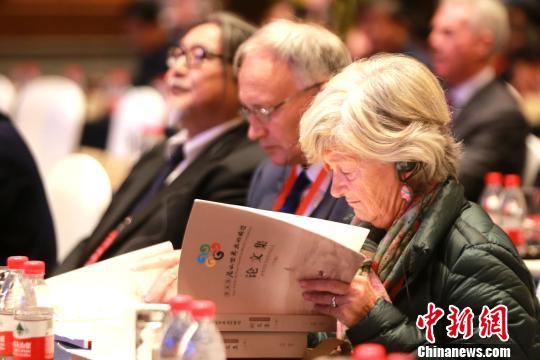 圖為在開幕式現(xiàn)場,，外國學者閱讀《第五屆尼山世界文明論壇論文集》?！×籂?攝