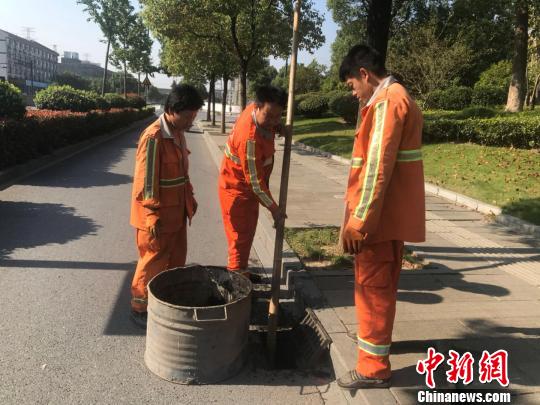 浙江省杭州市西湖區(qū)市政監(jiān)管科工作人員潘旭陽(左二)在清理淤泥,?！『莒?攝