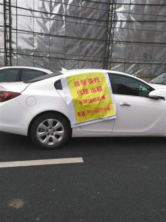 托管中介搶房大戰(zhàn)，搶房廣告甚至貼在車上,。新京報記者 黃鑫宇 攝