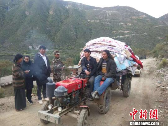 圖為當(dāng)?shù)厥転?zāi)村民轉(zhuǎn)移家用物資,?！〔际行麄鞑抗﹫D 攝