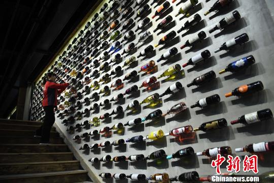 圖為工作人員正在展廳內(nèi)擦拭紅酒瓶?！￡惓?攝