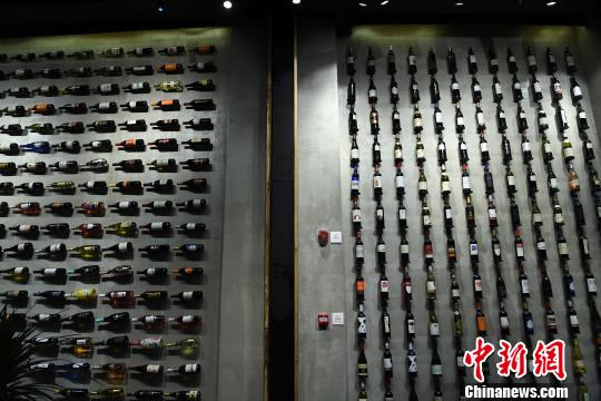 圖為展廳內(nèi)墻壁山掛滿了各類紅酒?！￡惓?攝
