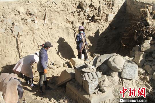 圖為工人正在挖掘石碑,?！≮w朗 攝