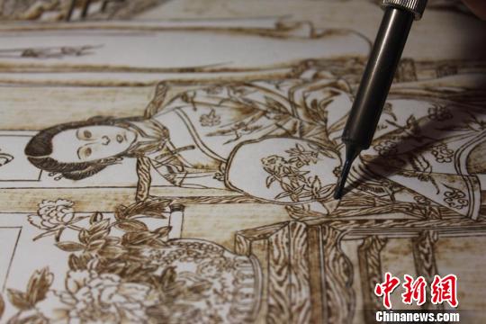 圖為正在創(chuàng)作中的烙畫作品,。　徐雪 攝