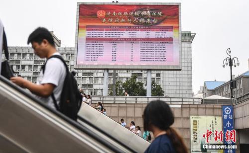 資料圖：2017年8月23日,，濟(jì)南火車站廣場(chǎng)大屏幕24小時(shí)循環(huán)播放失信被執(zhí)行人信息,，引得許多旅客駐足觀看。 <a target='_blank' href='http://www.chinanews.com/'>中新社</a>記者 張勇 攝