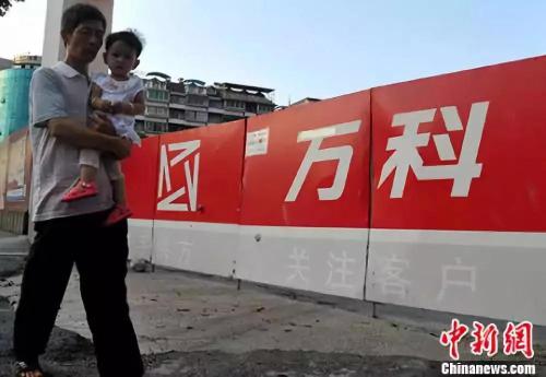 資料圖：福州民眾從萬科樓盤工地旁經(jīng)過,。<a target='_blank' href='http://www.chinanews.com/'>中新社</a>記者 張斌 攝