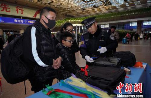 12月28日,，北京西站派出所民警為背黑色雙肩包的旅客系上個(gè)性小標(biāo)識(shí)，以防在通過(guò)安檢或乘車過(guò)程中出現(xiàn)錯(cuò)拿情況,。(完) 龐賀雷 攝