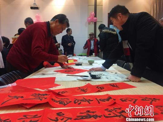 圖為書法愛(ài)好者為師生寫春聯(lián),?！埇| 攝