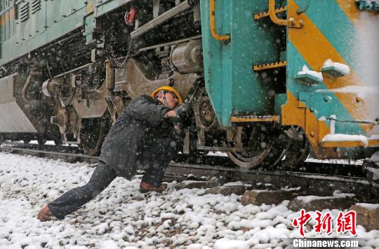 南京東機(jī)務(wù)段機(jī)車乘務(wù)員強(qiáng)化雪天機(jī)車走行部,、車鉤等關(guān)鍵部件檢查,，確保機(jī)車質(zhì)量良好，途中運(yùn)輸安全,?！⒔鸾?攝