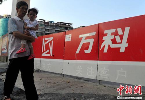 資料圖：民眾從萬科某樓盤工地旁經(jīng)過,。<a target='_blank' href='http://www.chinanews.com/'>中新社</a>記者 張斌 攝
