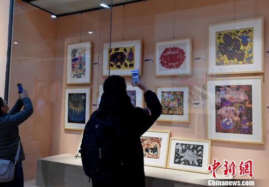 圖為《金豬賀歲》展覽,，觀眾觀看“豬文化”藝術(shù)品,。　周毅 攝