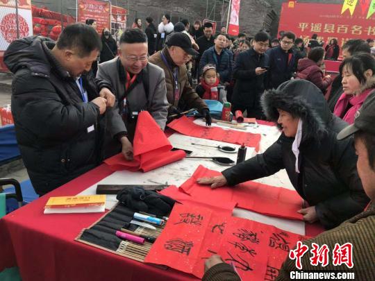 在古城南門內(nèi)的興國寺舊址，百名書法家揮筆潑墨,，向民眾贈送春聯(lián),。　胡健 攝